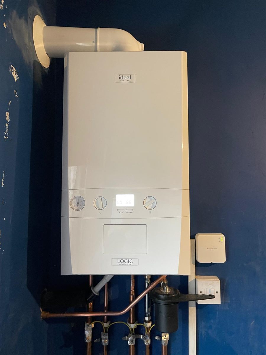 Newly installed Ideal Logic C24 combi boiler on a deep blue wall
